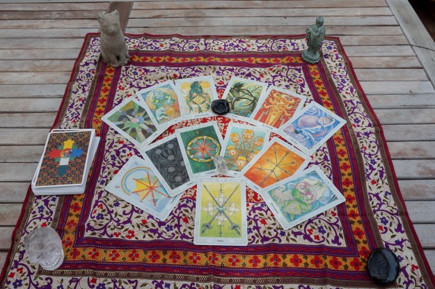 13 tarot cards on a patterned silk scarf.