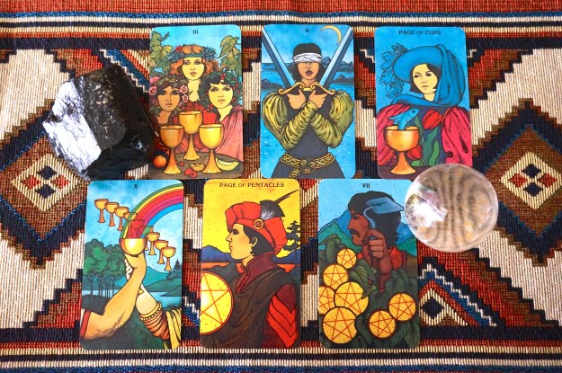 6 tarot cards and 2 crystals on a colorful background.